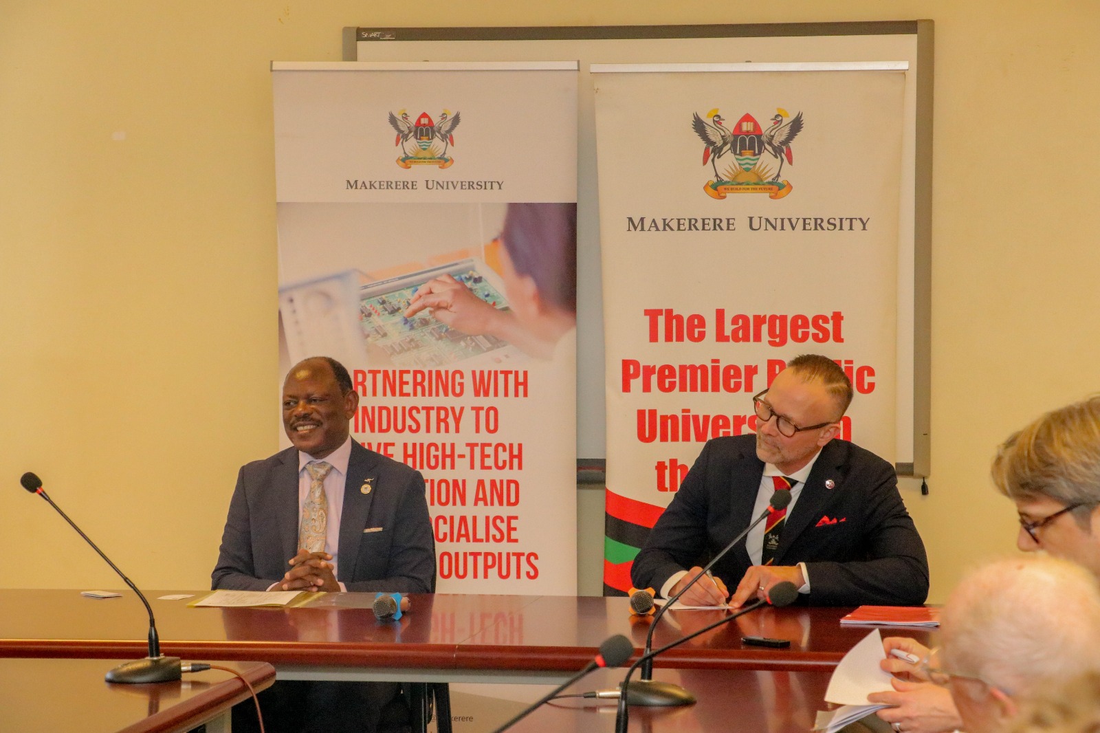 Prof. Barnabas Nawangwe and Prof. Martin Bergö interact with staff from Makerere University and Karolinska Institutet during the meeting.